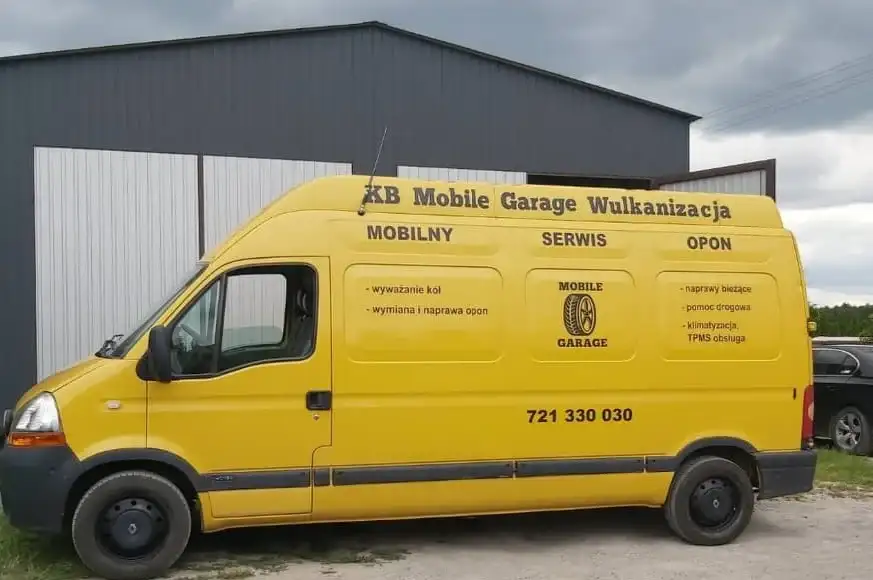 Żółty bus serwisowy KB Mobile Garage z napisem Mobilna Wulkanizacja przed halą warsztatu